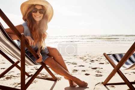 Foto de Me tomo el día para relajarme. Retrato de una joven relajada en una tumbona en la playa - Imagen libre de derechos
