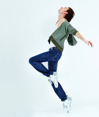 Téléchargez les photos : Homme, saute et danse dans les airs pour le bonheur avec action, mouvement et équilibre du corps isolé sur fond de studio blanc. Danseuse de ballet masculine, heureuse et libre avec énergie ou dansant sur la musique pour le plaisir. - en image libre de droit