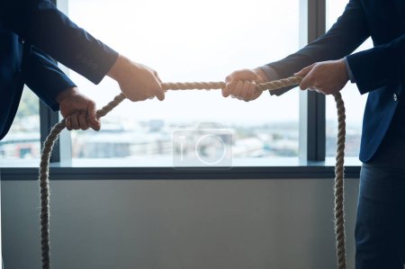 Photo for You have to work for what you want. two businessmen pulling on a rope in a game of tug of war - Royalty Free Image