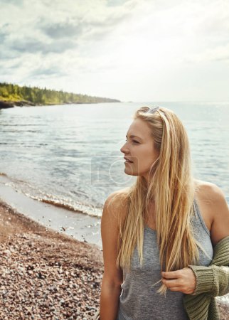 Téléchargez les photos : L'endroit idéal pour détendre l'esprit. une jeune femme passant une journée au lac - en image libre de droit