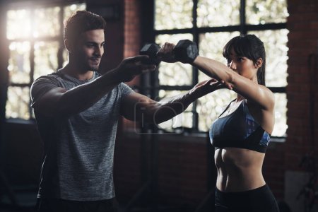 Photo for Youre capable of more than you imagined. a young man and woman working out at the gym - Royalty Free Image