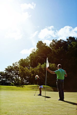Photo for The goal is the hole. a couple playing golf together on a fairway - Royalty Free Image