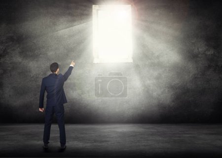 Back, opportunity and a business man with window light for access on a dark background with mockup. Wall, career and male professional and CEO pointing the way to future growth, success or leadership.