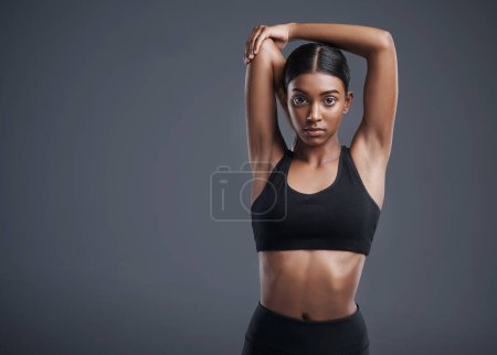 Photo for Portrait, mock up and stretching with an athlete woman in studio on a gray background for fitness or health. Exercise, workout or getting ready with an attractive young female model training her body. - Royalty Free Image