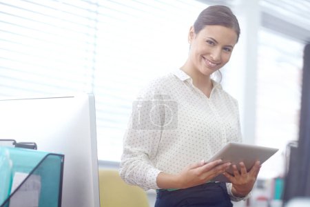 Photo for Achieving success with the help of her tablet. Portrait of an attractive young businesswoman using a digital tablet during work - Royalty Free Image
