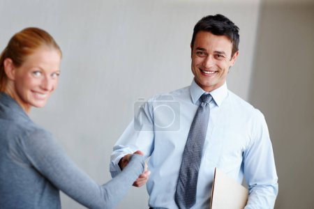 Photo for Making good business acquaintances. A young businessman shaking hands with a female coworker - Royalty Free Image