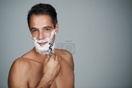Photo for Starting the day with a shave. Studio portrait of a handsome mature man shaving his face - Royalty Free Image