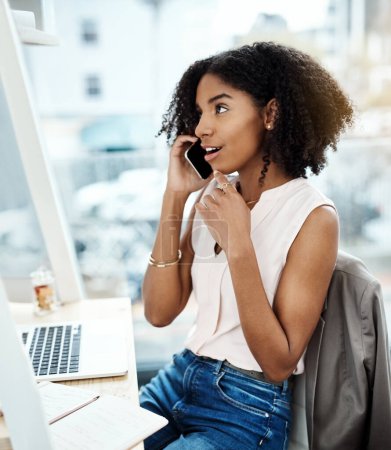Photo for Phone call, talking and young woman in office for feedback, news or online discussion at startup business. Happy african person thinking and listening on cellphone, mobile or voip for client ideas. - Royalty Free Image