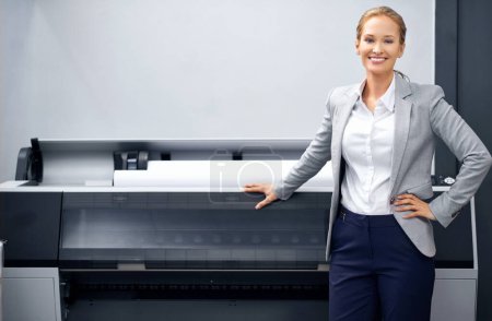 Photo for Fulfilling all your print needs. A self-assured young publisher standing alongside a printing machine - Royalty Free Image