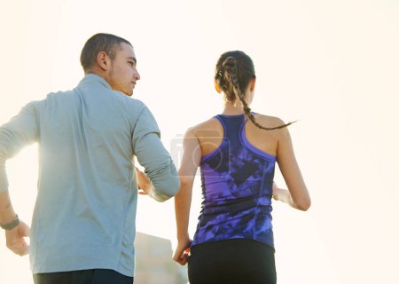 Téléchargez les photos : Courir au lever du soleil. Vue arrière de deux amis faisant du jogging dans la ville - en image libre de droit