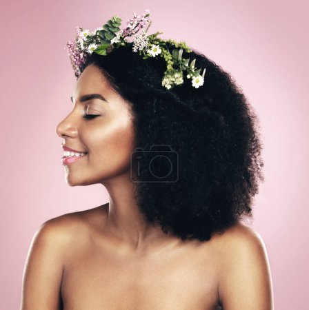 Photo for Happy woman, face and flower crown for beauty in studio, pink background and natural skincare. Smile, african model and plants for floral wreath, spring cosmetics and dermatology of afro hair care. - Royalty Free Image
