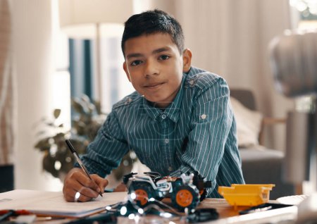 Photo for Learning, writing and portrait of kid with robotics homework, homeschool and science for tech project. Taking notes, car robot and boy child with knowledge, education and studying in house alone - Royalty Free Image