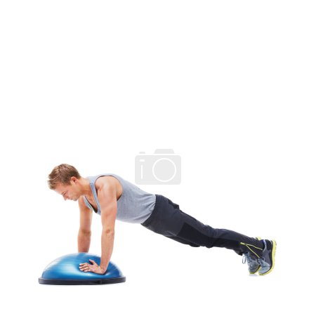 Foto de Su plan de entrenamiento es simple pero efectivo. Un joven haciendo flexiones en una bola de bosu - Imagen libre de derechos