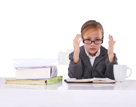 Photo for Growing up to be the boss. A cute little girl dressed up in business attire while sitting at a desk looking frustrated and tired - Royalty Free Image
