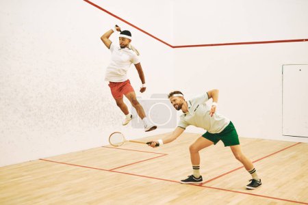 Téléchargez les photos : Restez léger sur vos pieds. deux jeunes hommes jouant à un jeu de squash - en image libre de droit