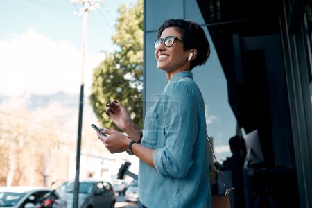 Foto de Esperando a que llegue mi cliente. una atractiva joven empresaria parada sola afuera y usando su celular en la ciudad - Imagen libre de derechos