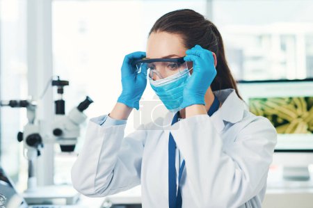Photo for Goggles on. an unrecognizable young female scientist putting on a protective face mask inside of a laboratory during the day - Royalty Free Image