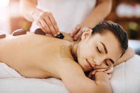 Photo for Therapy, relax and woman getting a hot stone back massage at spa for luxury, calm and natural self care. Beauty, body care and tranquil female person sleeping while doing rock body treatment at salon. - Royalty Free Image