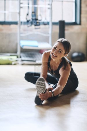 Photo for Portrait, smile and woman stretching, fitness and workout goal with balance, stress relief and happiness. Face, female person or athlete on the floor, stretch legs and training for wellness or health. - Royalty Free Image