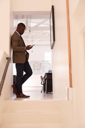 Photo for Business, man and and typing on smartphone in office corridor, online contact or digital technology. Black male worker texting on cellphone, social networking app or mobile search on media connection. - Royalty Free Image