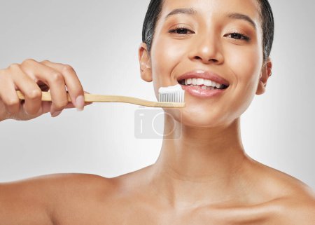 Photo for Healthy teeth are always in style. Studio portrait of an attractive young woman brushing her teeth against a grey background - Royalty Free Image