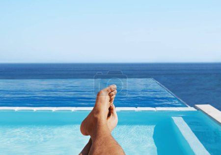 Foto de POV, pies y el hombre relajarse en una piscina para viajar y vacaciones de verano en el mar por el hotel y el agua. Persona descalza, tranquila y viajera al aire libre en vacaciones junto a la piscina o descansar en un resort de lujo en Maldivas. - Imagen libre de derechos