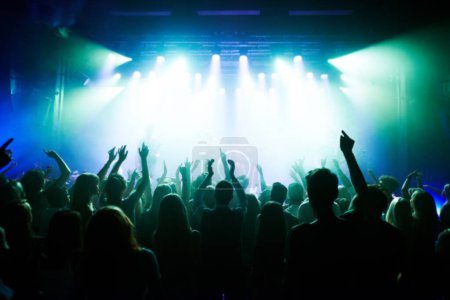 Music, dance and party with crowd at concert for rock, live band performance and festival show. New year, celebration and disco with audience of fans listening to techno, rave and nightclub event.