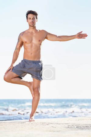 Photo for Fitness, man and yoga tree pose on beach for exercise or stretching body in workout or training in nature. Fit, active or male yogi in warm up stretch, cardio or exercising in balance on ocean space. - Royalty Free Image