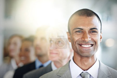 Téléchargez les photos : Homme d'affaires heureux, portrait et visage dans la gestion, le leadership ou la diversité au bureau. Un dirigeant d'entreprise confiant avec le sourire dans un groupe diversifié, le travail d'équipe ou l'unité pour la vision d'entreprise sur le lieu de travail. - en image libre de droit