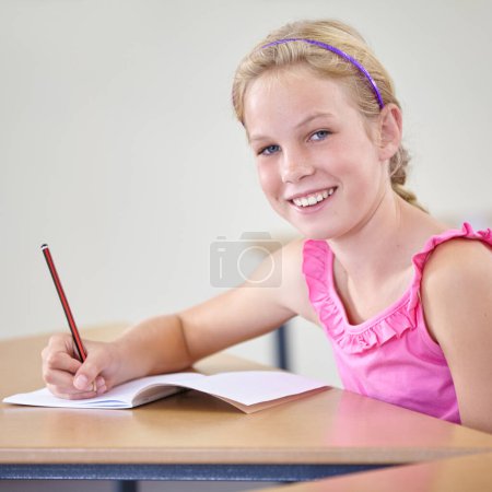 Photo for Portrait, child and education of student taking notes in classroom for knowledge, development and happy. Smile, girl and learner writing in notebook, studying or learning in middle school in Canada - Royalty Free Image