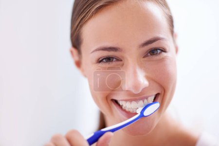 Photo for Young woman, portrait and brushing teeth in bathroom with smile, health or self care for hygiene, grooming and routine. Girl, toothbrush and happiness for cleaning, healthy mouth and start morning. - Royalty Free Image