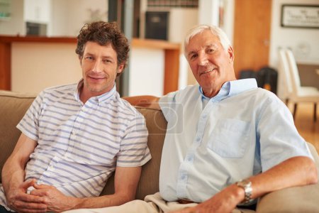 Téléchargez les photos : Temps de liaison détendu avec papa. un homme et son père assis ensemble sur le canapé à la maison - en image libre de droit