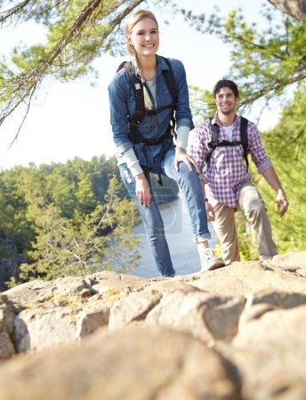 Foto de Tomando un momento para descansar. Una joven pareja de senderismo y subir a la ladera de la montaña juntos - Imagen libre de derechos