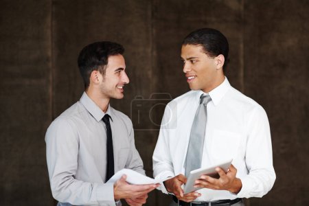 Foto de Compartir ideas corporativas. Dos hombres de negocios profesionales discutiendo usando una tableta digital - Imagen libre de derechos