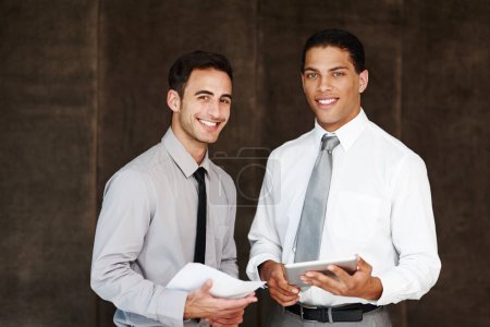 Foto de Son un dúo de negocios dinámico. Dos hombres de negocios profesionales discutiendo usando una tableta digital - Imagen libre de derechos