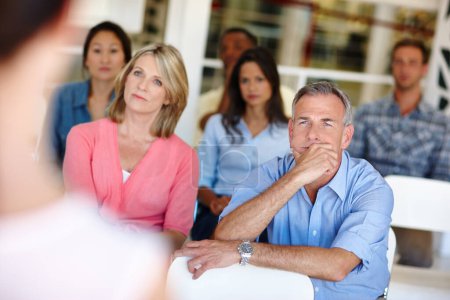 Photo for I never thought of it that way. coworkers watching a presentation in a casual office environment - Royalty Free Image