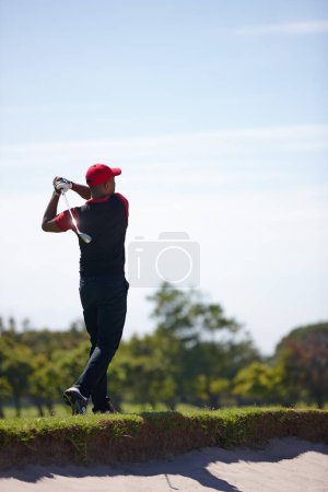 Foto de Qué buen aspecto seguir adelante. un joven guapo jugando un juego de golf - Imagen libre de derechos