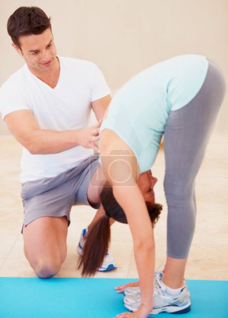 Téléchargez les photos : Homme, yoga et entraîneur personnel avec jeune femme étirant le corps pour la forme physique, l'exercice ou l'entraînement à la salle de gym. Instructeur, entraîneur ou mentor de yogi masculin aidant la femme à s'échauffer, à s'étirer ou à poser sur un tapis de sol. - en image libre de droit