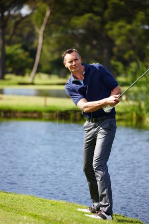 Téléchargez les photos : Visez et laissez voler. un homme prenant une balançoire dans un jeu de golf - en image libre de droit