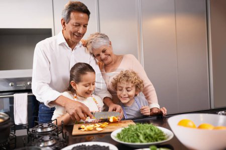 Téléchargez les photos : Nourriture, grands-parents ou enfants heureux apprennent à cuisiner pour un dîner sain avec des fruits ou légumes à la maison. Enseigner aux enfants, couteau ou grand-mère avec un vieil homme ou un repas diététique nutrition dans la cuisine. - en image libre de droit