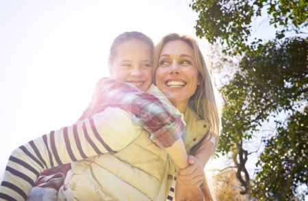 Photo for Hug, piggyback and happy kid, mom or free people enjoy family time, freedom and wellness on bonding walk. Sky, sun flare and youth girl with mother, mama or woman smile for outdoor fun on Mothers Day. - Royalty Free Image