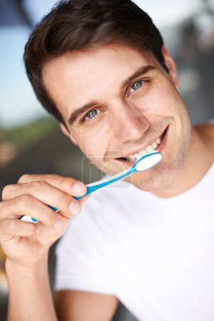 Foto de Cepillarse los dientes, retrato de hombre y limpieza de primer plano para la higiene bucal y la salud. Sonrisa, dental y cepillo de dientes con una cara de persona masculina con felicidad en la mañana en una casa con autocuidado y rutina. - Imagen libre de derechos