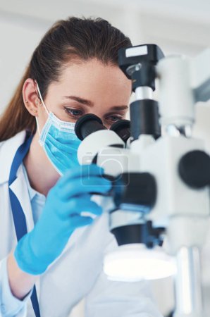 Photo for There seems to be changes. a focused young female scientist looking through a microscope while doing tests inside of a laboratory - Royalty Free Image
