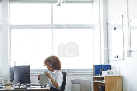 Photo for Shes always the first one in. a beautiful young businesswoman in her office - Royalty Free Image