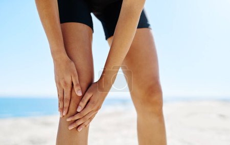 Photo for Warming up to avoid sports injuries. a sporty young woman suffering from a sports injury - Royalty Free Image