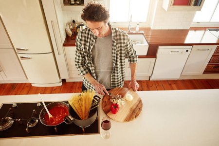 Photo for Food, cooking or above of man in kitchen with healthy vegan diet for nutrition or vegetables at home in Australia. Wine glass, spaghetti or male person in house kitchen in preparation for dinner meal. - Royalty Free Image