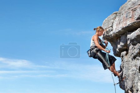 Photo for Rock climbing, blue sky and freedom with woman on mountain cliff for adventure or travel with space. Strong, challenge and mockup with female climber training in nature for courage, safety or workout. - Royalty Free Image