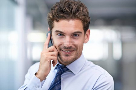 Foto de ¿Puedo hablar con tu jefe? Un joven empresario al teléfono en la oficina - Imagen libre de derechos