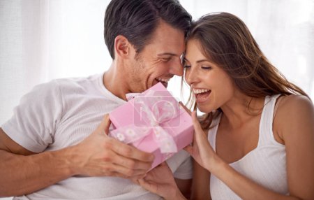 Foto de Man giving woman gift, love and happiness with partnership, relationship and celebration on Valentines day date. Couple laugh with present, luxury and commitment, gratitude and celebrate holiday. - Imagen libre de derechos