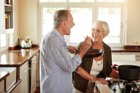 Photo for Taste, happy or old couple kitchen cooking with healthy food for lunch or dinner together at home in retirement. Senior woman tasting or smiling with mature husband in meal preparation in Australia. - Royalty Free Image